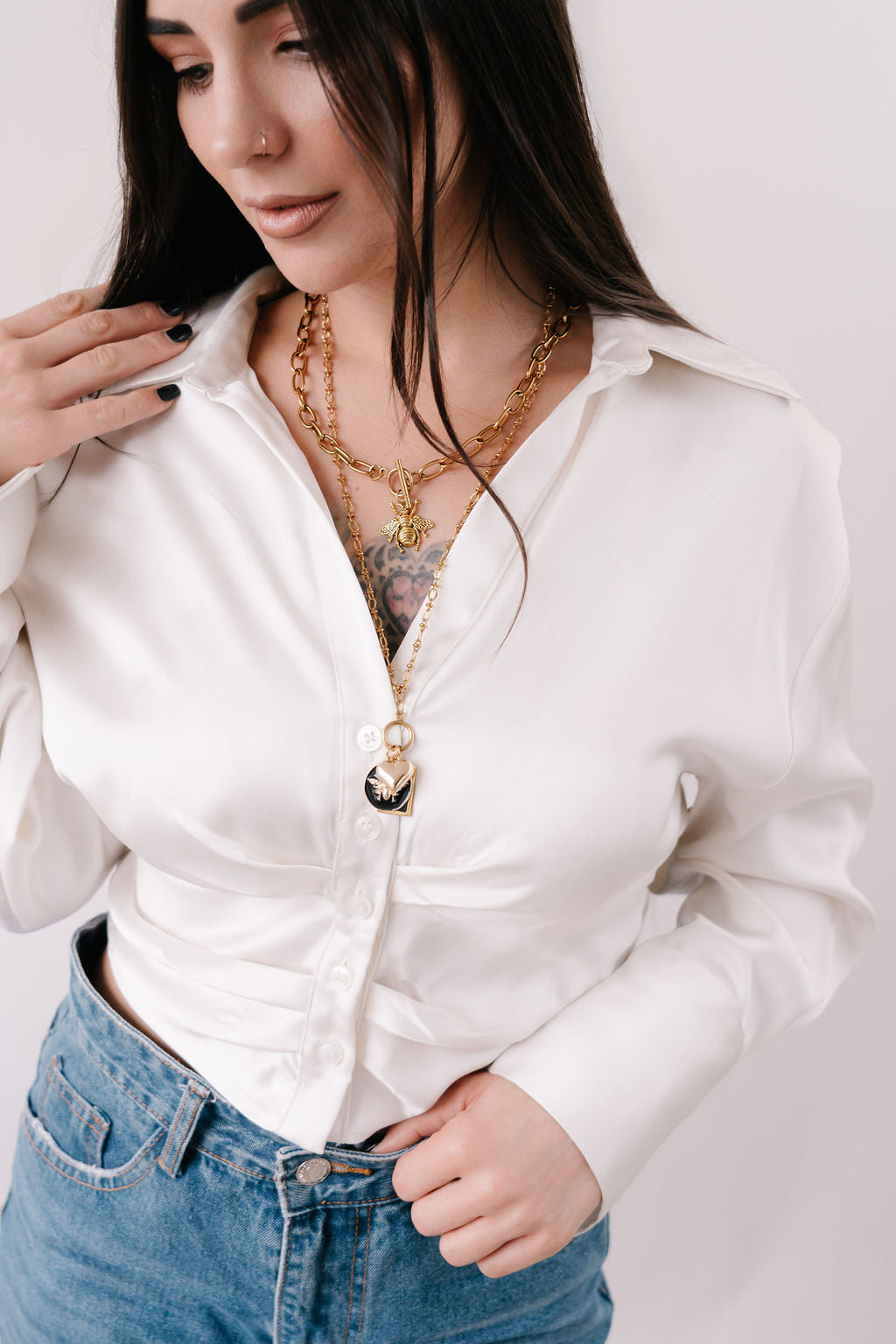 Fine detailed chain with hanging gold disc and 3 charms; round black enamel bee, square black charm and delicate 3D heart